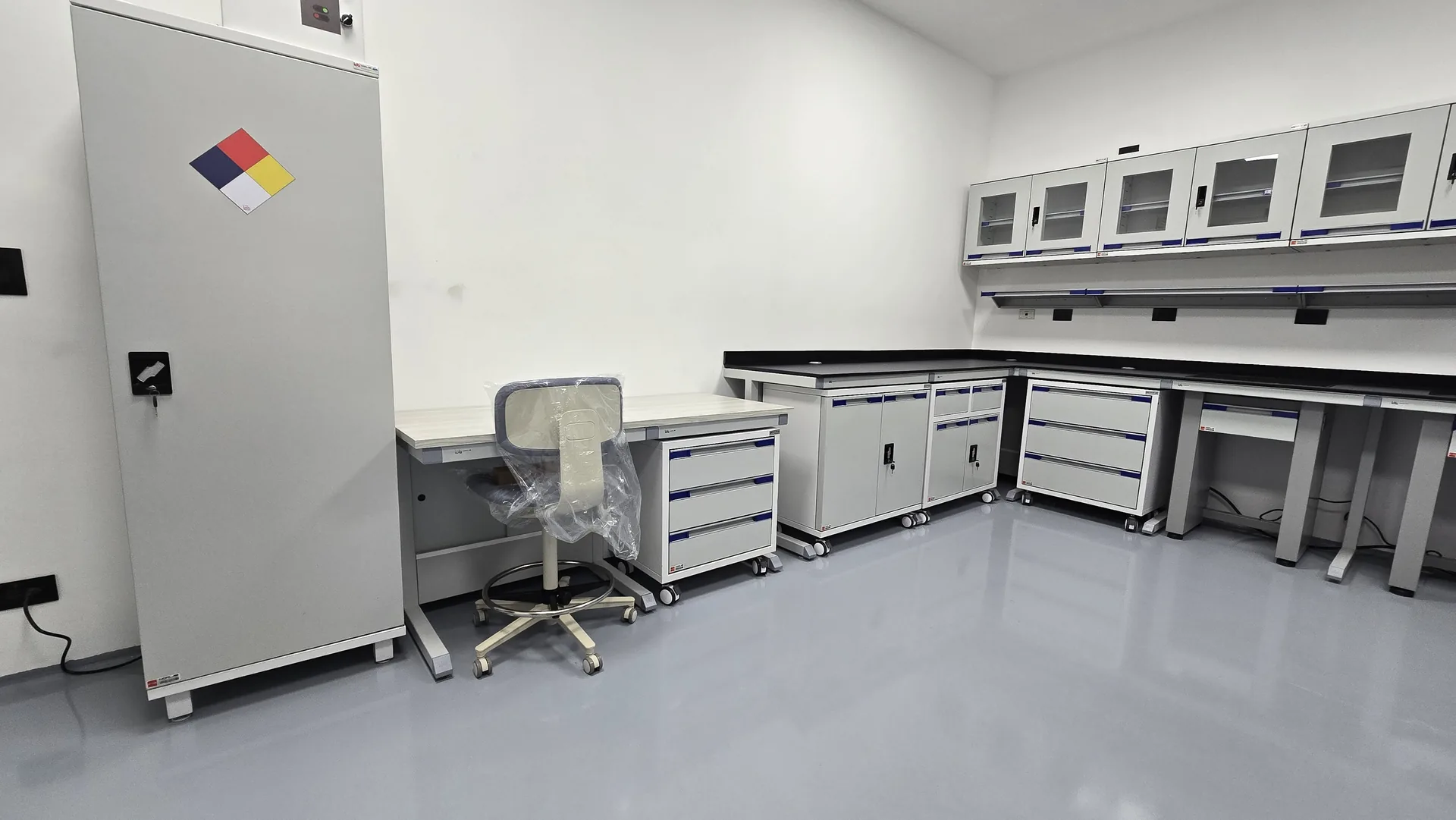 Bancos con cubierta negra y gabinetes de vidrio en el laboratorio de DUG Spirits